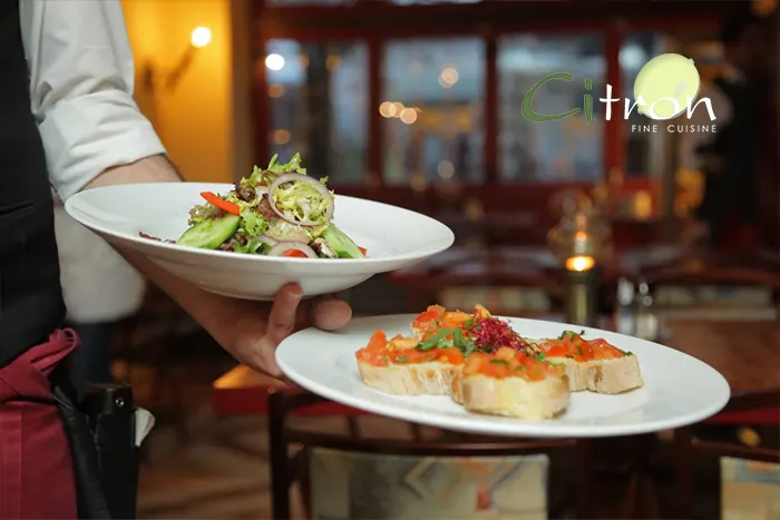 Server presenting plates at Citron Fine Cuisine