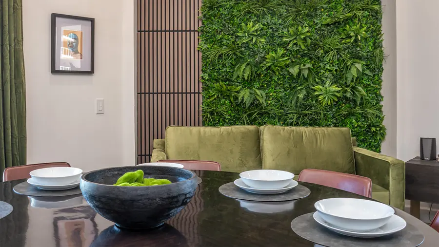 Dining table set for dinner beside the green wall