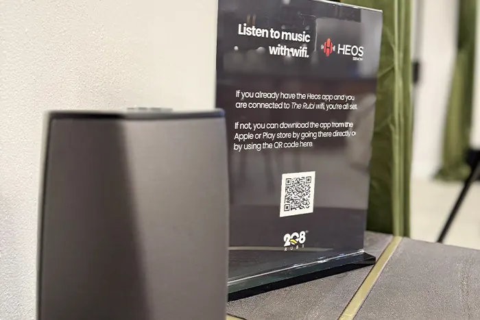 HEOS Wi-Fi speaker with setup instructions at Rubi 208