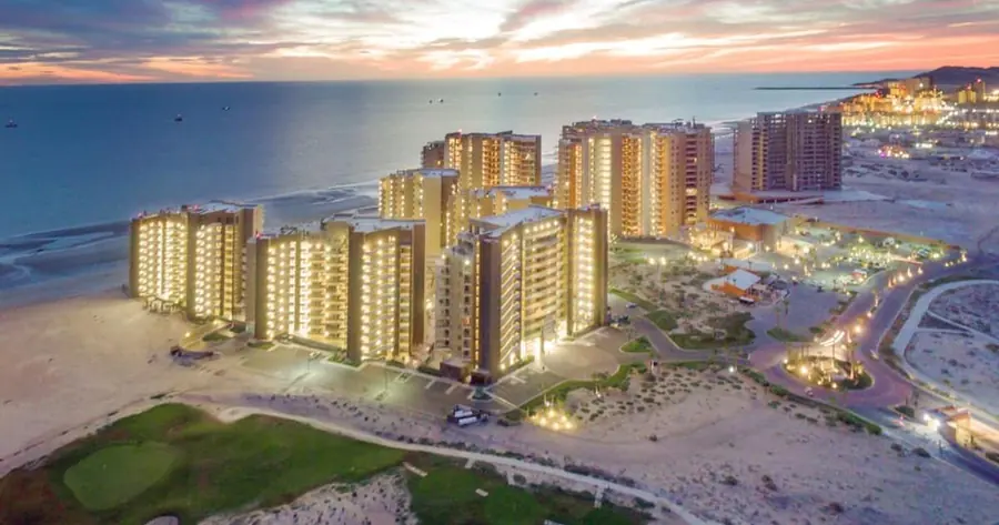 Las Palomas Beach & Golf Resort towers lit up at sunset