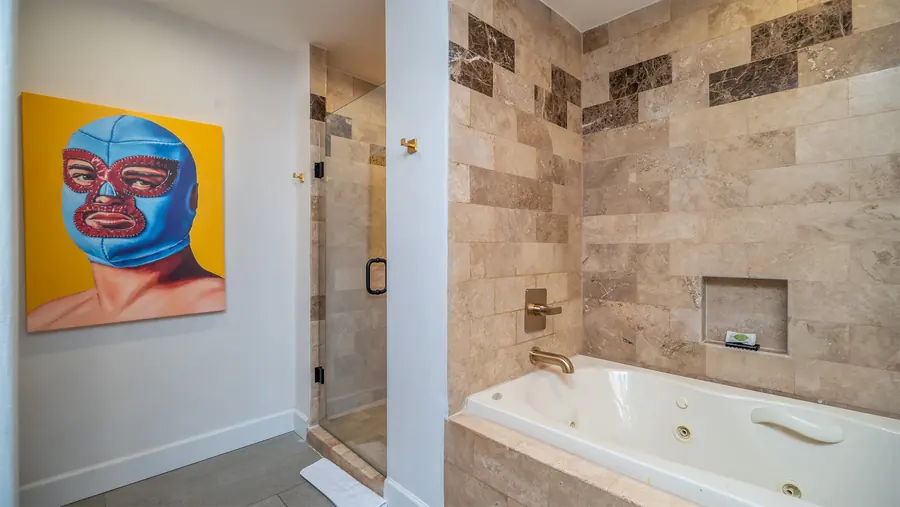 Master bath with jacuzzi tub and Lucha libre artwork