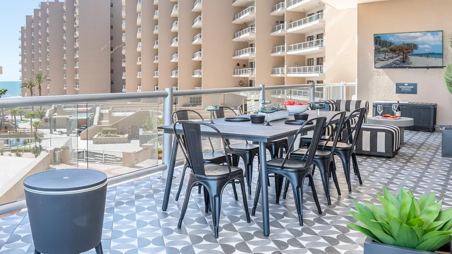 Outdoor patio dining table at Rubi 208 with Las Palomas towers and ocean