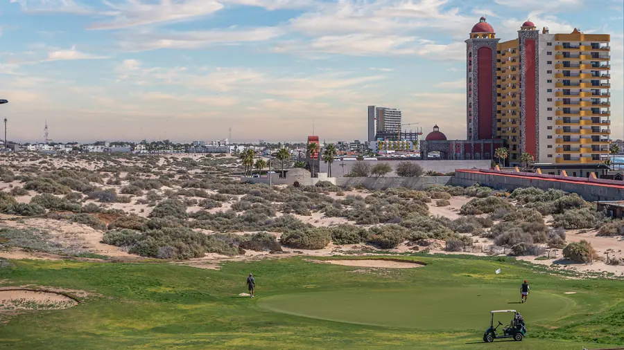 Putting green at The Links with Rocky Point towers in the distance